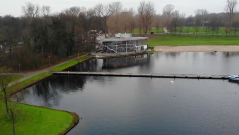 drone view of kralingen lake with waterfront glass pavilion in rotterdam, netherlands