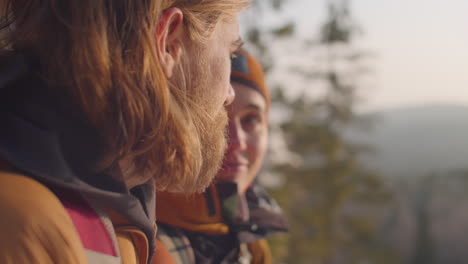 couple discussing scenic view of winter woods from mountain