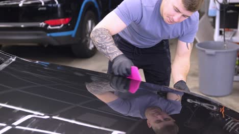 man covering car with vinyl polyurethane tape. films for the car. sticker protective film on the car