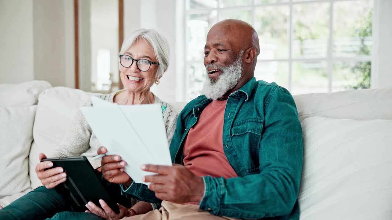 Old couple on sofa with paperwork
