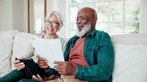 old couple on sofa with paperwork