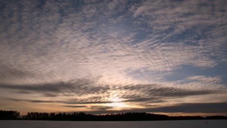 Lapso-De-Tiempo-De-Las-Nubes-Moviéndose-En-Diferentes-Direcciones-Al-Atardecer-En-El-Lago-Helado