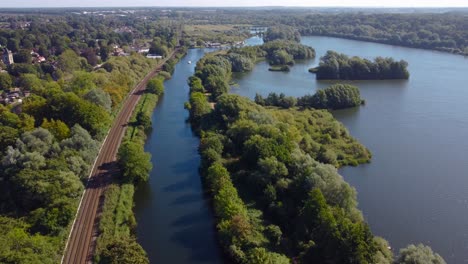 wide aerial shot of lake, forest, railroad and town of norwich, england