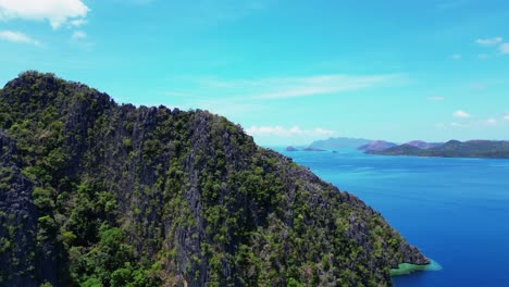 Lago-Kayangan-En-Un-Día-Soleado-Bandeja-Aérea-Ascendente-A-La-Izquierda-De-Las-Montañas-Coron