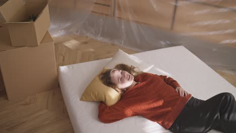 woman relaxing on mattress during a move