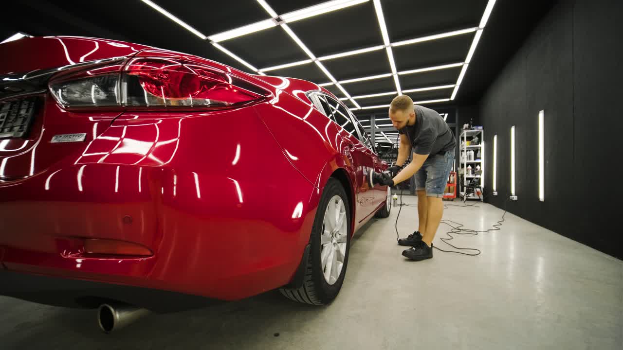 trabajador pulir un coche rojo. detalles de automóviles - los hombres están usando maquinaria pulidores de automóviles mantenimiento para eliminar marcas reparación de acuerdo con la superficie de la pintura del coche antes de continuar a recubrir la cerámica