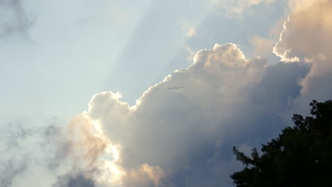 A-plane-flies-into-a-thick-cloud-with-a-silver-lining-during-sunset