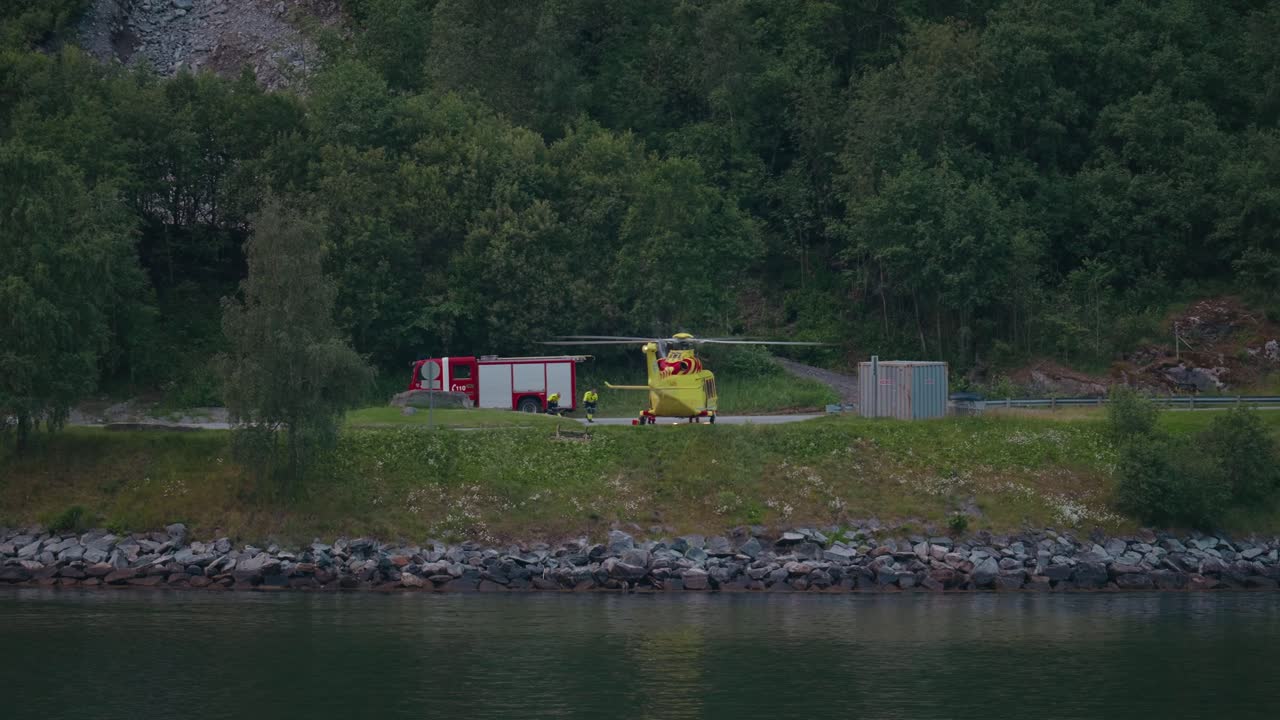 Rescue helicopter and fire truck in lush Geiranger Fjord, Norway