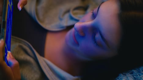 teenage girl relaxing on a cozy couch, intently using her smartphone. warm natural lighting enhances the tranquil and casual atmosphere.