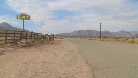 Un-Restaurante-Abandonado-Con-Un-Letrero-Que-Dice-Comer-En-El-Desierto-De-Mojave