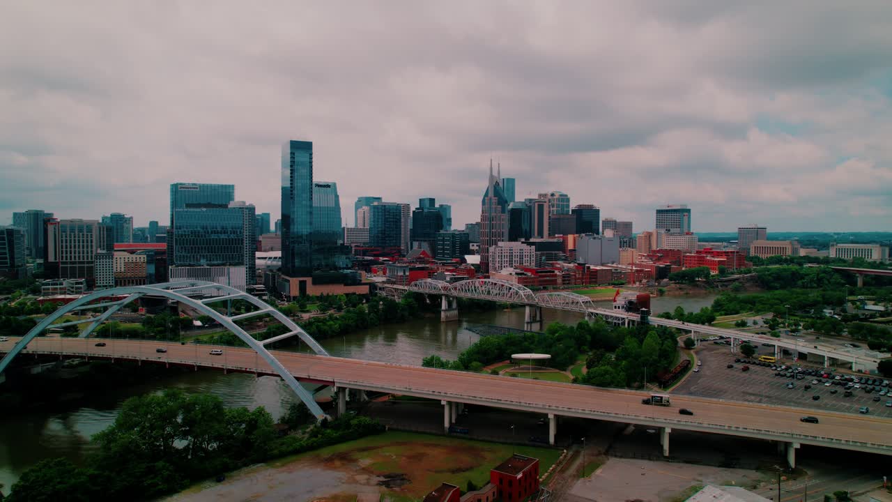 Warm golden hour drone footage showcasing Nashville’s vibrant downtown, the iconic pedestrian walkway, and reflective riverbanks in soft evening light.
