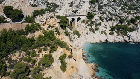 Aerial-orbit-to-reveal-railroad-bridge-on-coast-of-France-with-stunning-turquoise-water