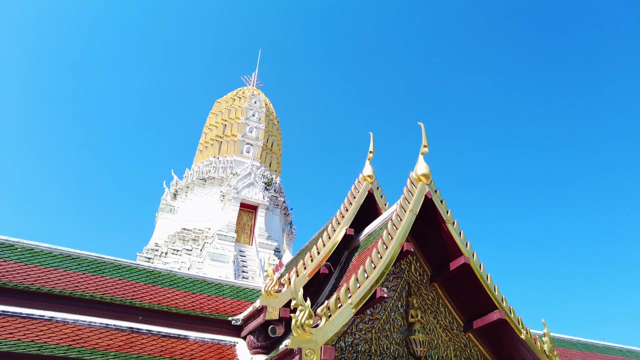 タイのワット・プラシーラッタナーマハータートにある金色の装飾された寺院の屋根と古代のプラーン塔に固定されたカメラ