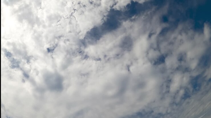 Stratus cloudscape covering the blue skies. Low angle view on the clouds gathering in the atmosphere. Timelapse.