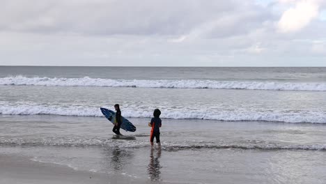 two surfers preparing to enter the ocean