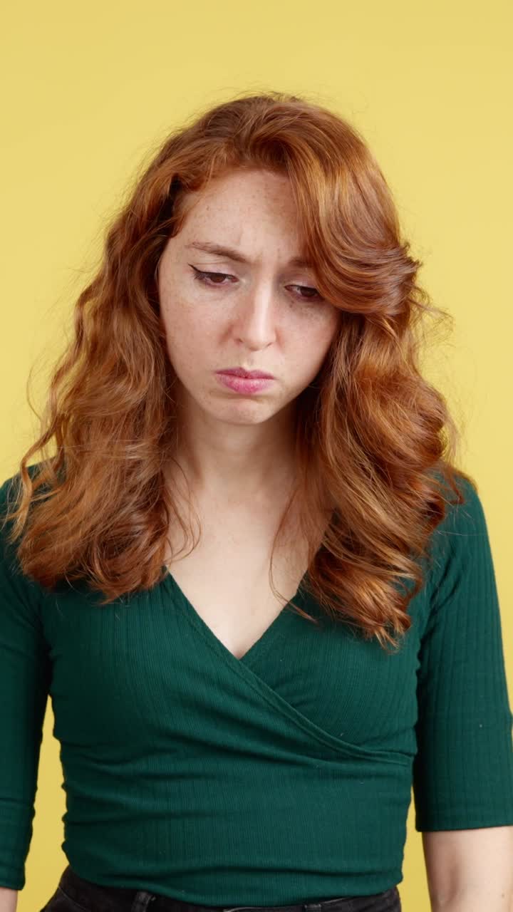 A red-haired woman expressing sadness and distress, with open and closed eyes