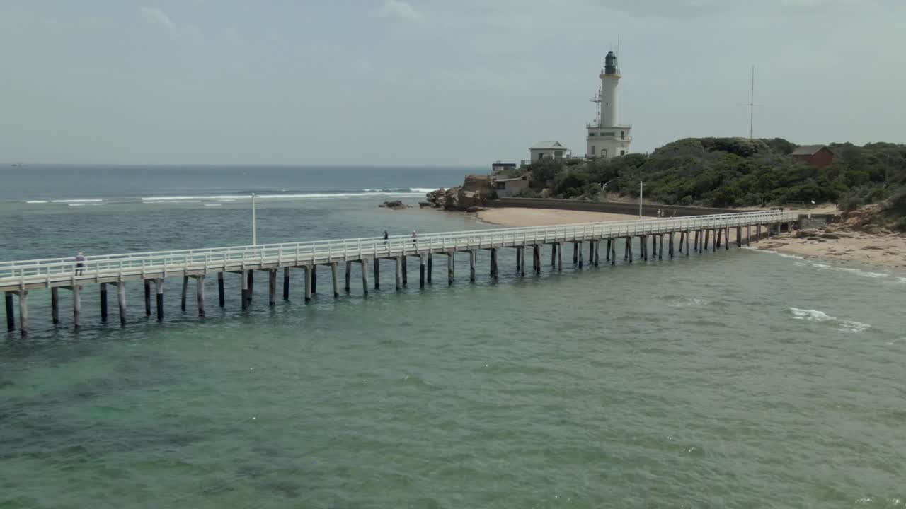Scenic View of a Lighthouse and Pier on a Coastal Beach