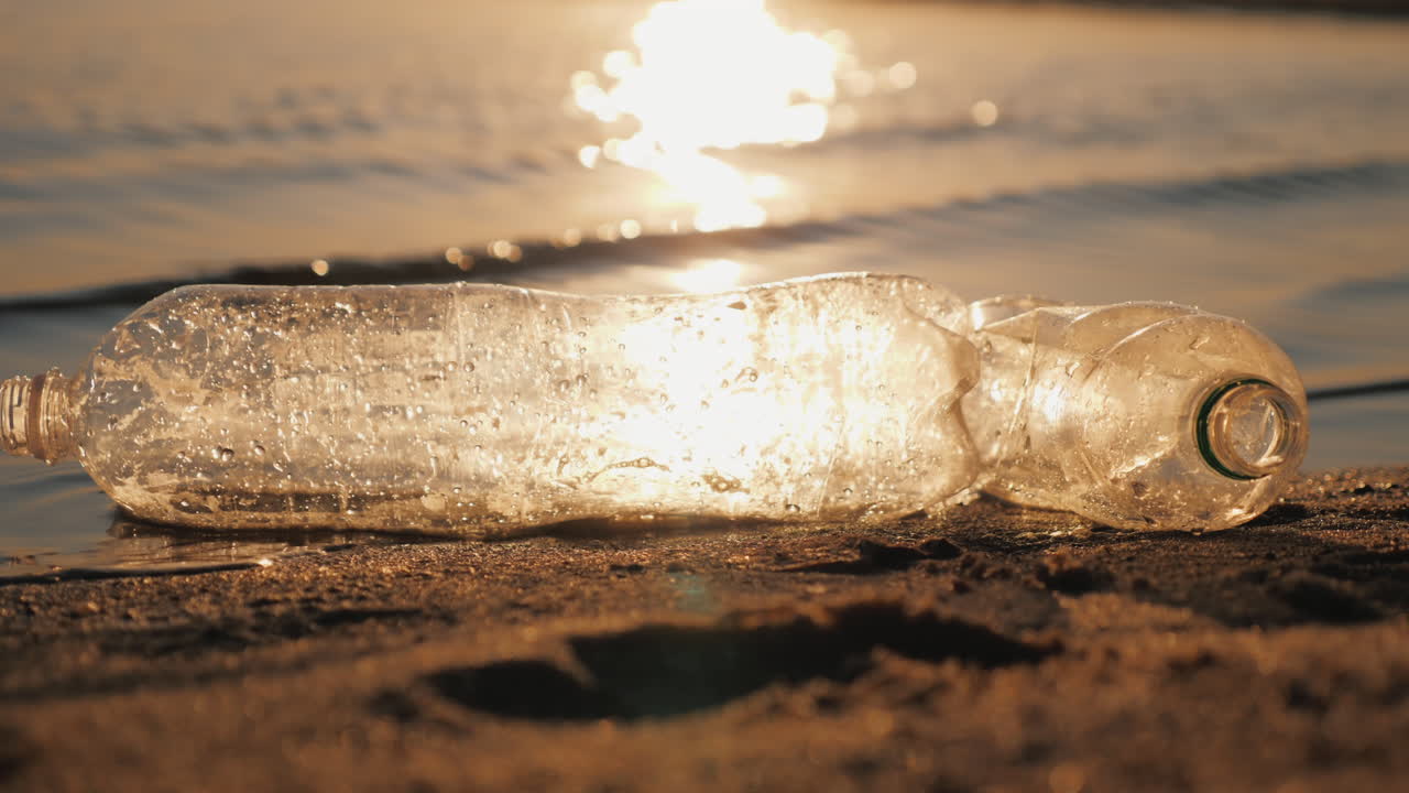 해안 플라스틱 오염 개념 근처의 물에 두 개의 플라스틱 병이 떠 있습니다.