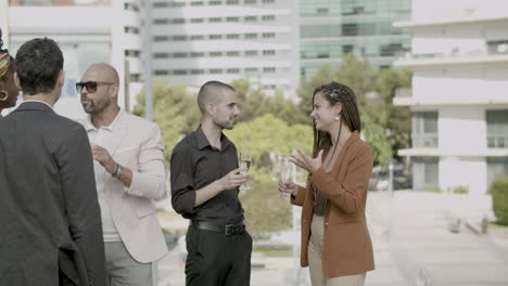 employees drinking sparkling wine and talking at business party