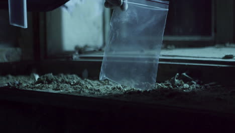investigador de ciencias forenses poniendo evidencia o cadena en una bolsa de plástico, vista detallada de manos y pinzas
