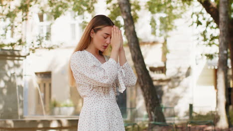 Mujer-Joven-Caucásica-Rezando-Con-Los-Ojos-Cerrados-A-Dios-Pidiendo-Bendición-Ayuda-Perdón-Al-Aire-Libre