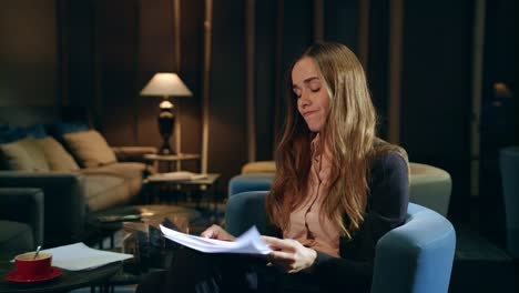 Angry-business-woman-reading-financial-report-in-hotel-lobby-at-evening