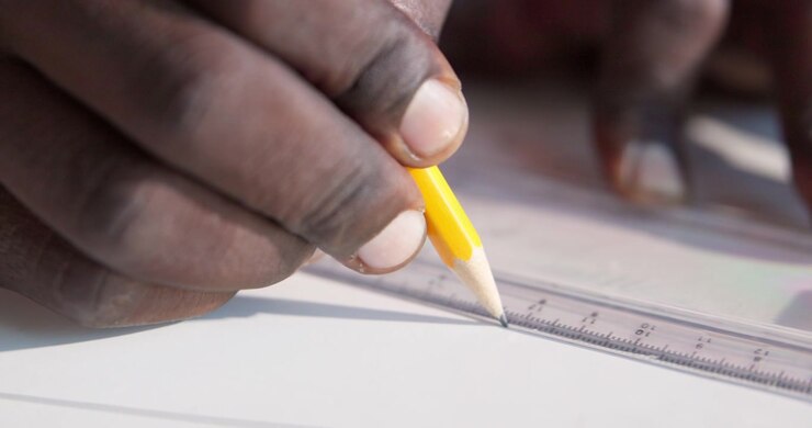 Close-up of Person Drawing a Straight Line with a Pencil and Ruler