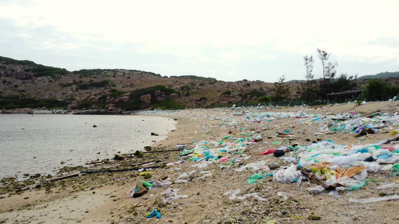 vista a nivel del suelo de la playa contaminada en ninh thuan, llena de bolsas de plástico