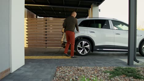 hombre cargando un vehículo eléctrico en casa