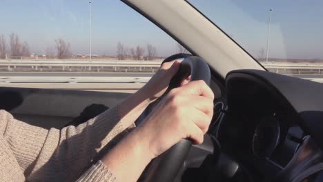 Female-driver-on-road-trip,-woman-holding-steering-wheel-of-a-car