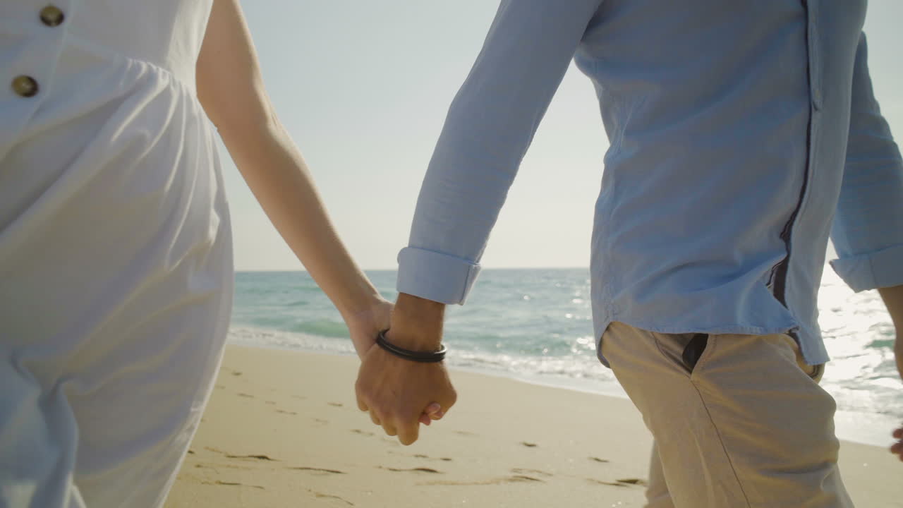 손을 잡고 해변에서  ⁇ 고 있는 커플의  ⁇   ⁇