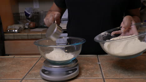 black woman measures and weighs kamut or khorasan wheat flour on scale, closeup