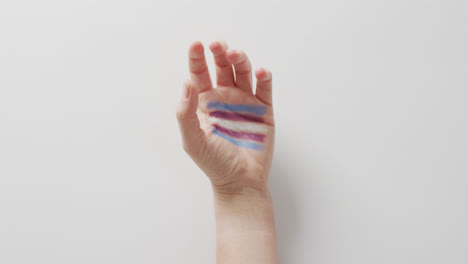 video of hand of caucasian man with rainbow flag on white background