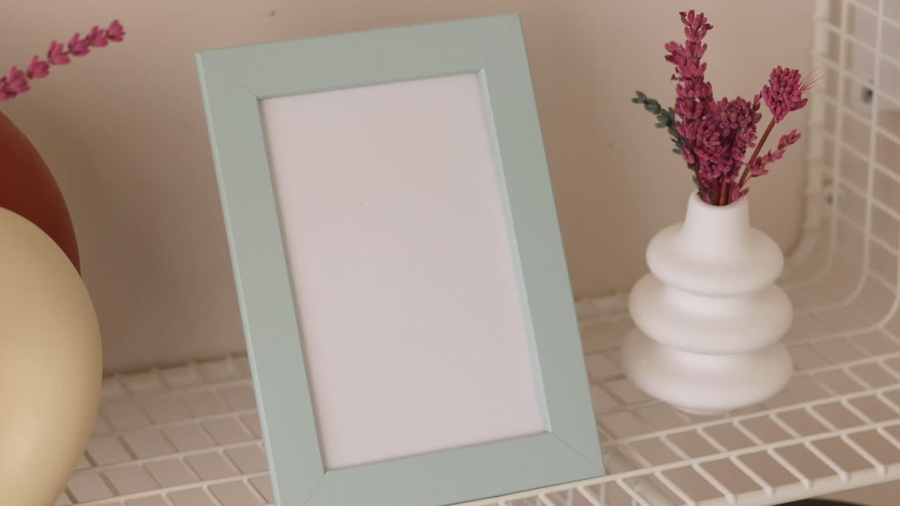 marco de imagen vacío de color verde claro con jarrones decorativos y flores secas