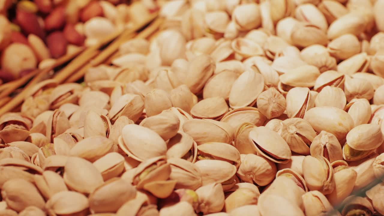 Tasty unpeeled pistachios rotates on market barcelona, top view, close up. Pistachios texture and background.