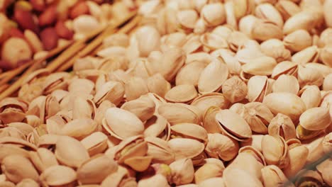tasty unpeeled pistachios rotates on market barcelona, top view, close up. pistachios texture and background.