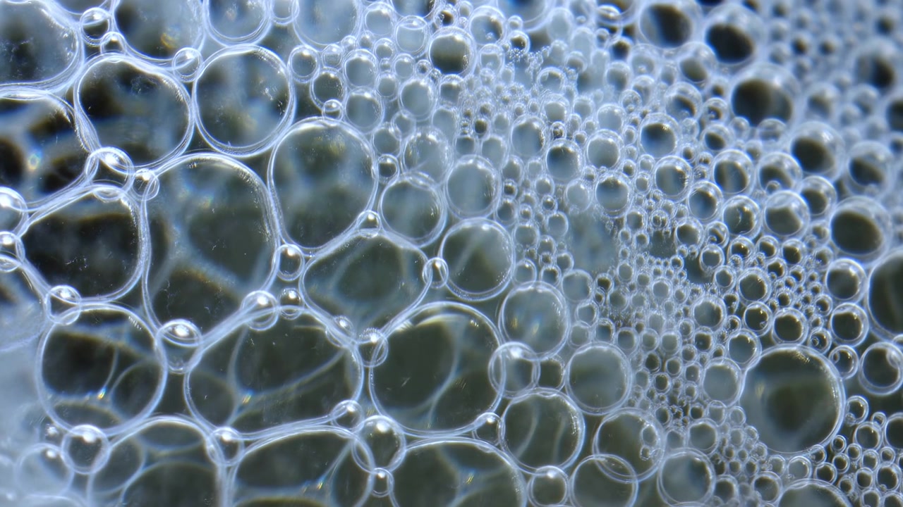 Primer plano de la superficie líquida con burbujas de espuma flotantes de diferentes tamaños, ambiente neutro, fondo limpio, espacio para texto, moderno, brillante, vívido, recurso de diseño, banner web, póster, espacio para copiar