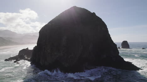 Shadowy-Haystack-Rock-behind-the-ocean-spray-of-the-Pacific