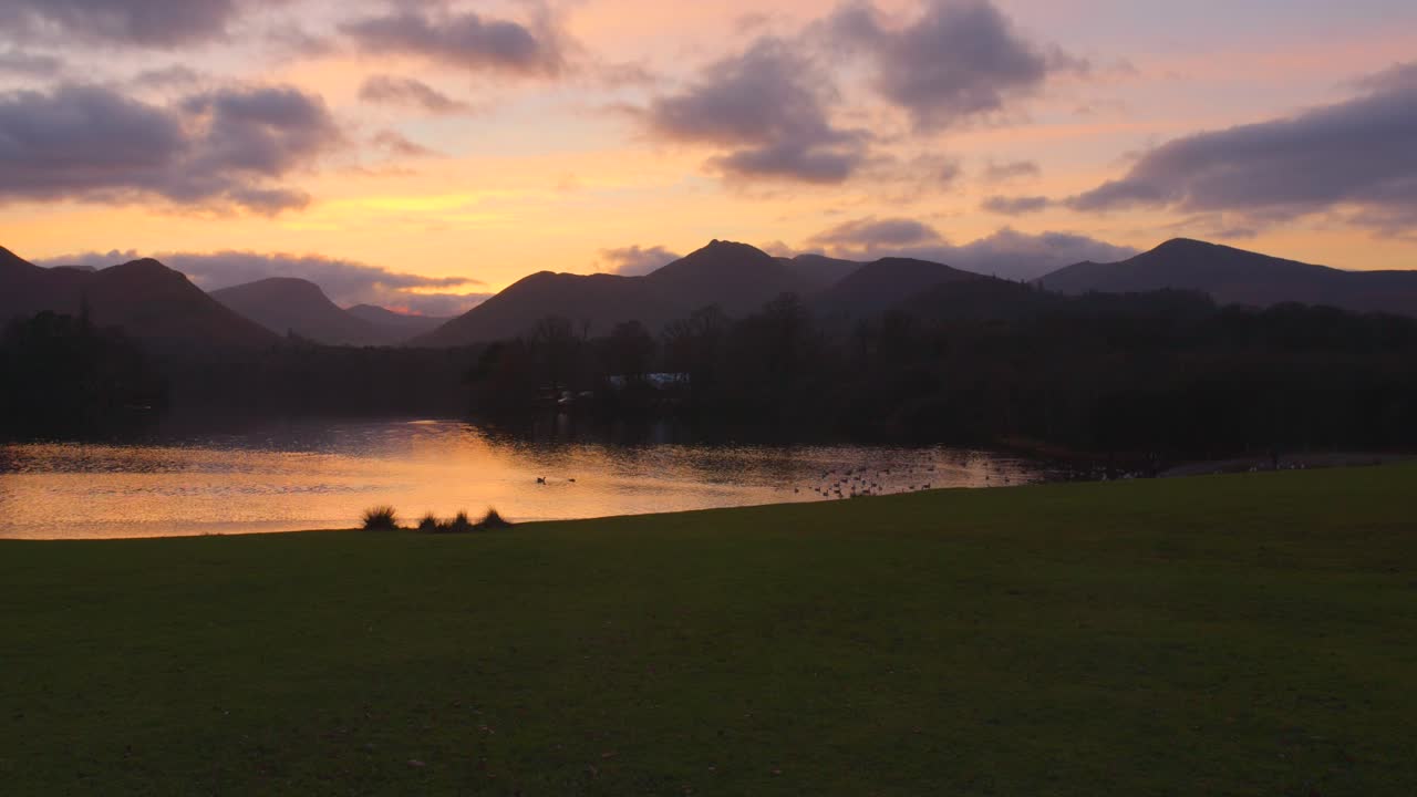 영국 레이크 디스트릭트 (lake district) 의 조용한 물에 있는 실루  (silhouetted fells) 과 함께 데르벤트 워터 (derwentwater) 에서 해가 지는 색