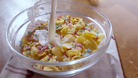 flocos de maíz amarillos crujientes en el cuenco para la mañana un delicioso desayuno con leche. cámara lenta con toma de seguimiento de rotación.