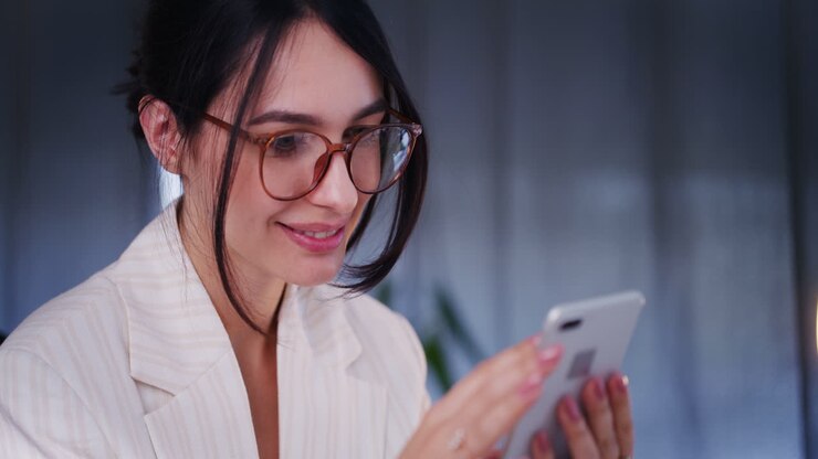 Donna d'affari sicura di sé che naviga su Internet sullo smartphone