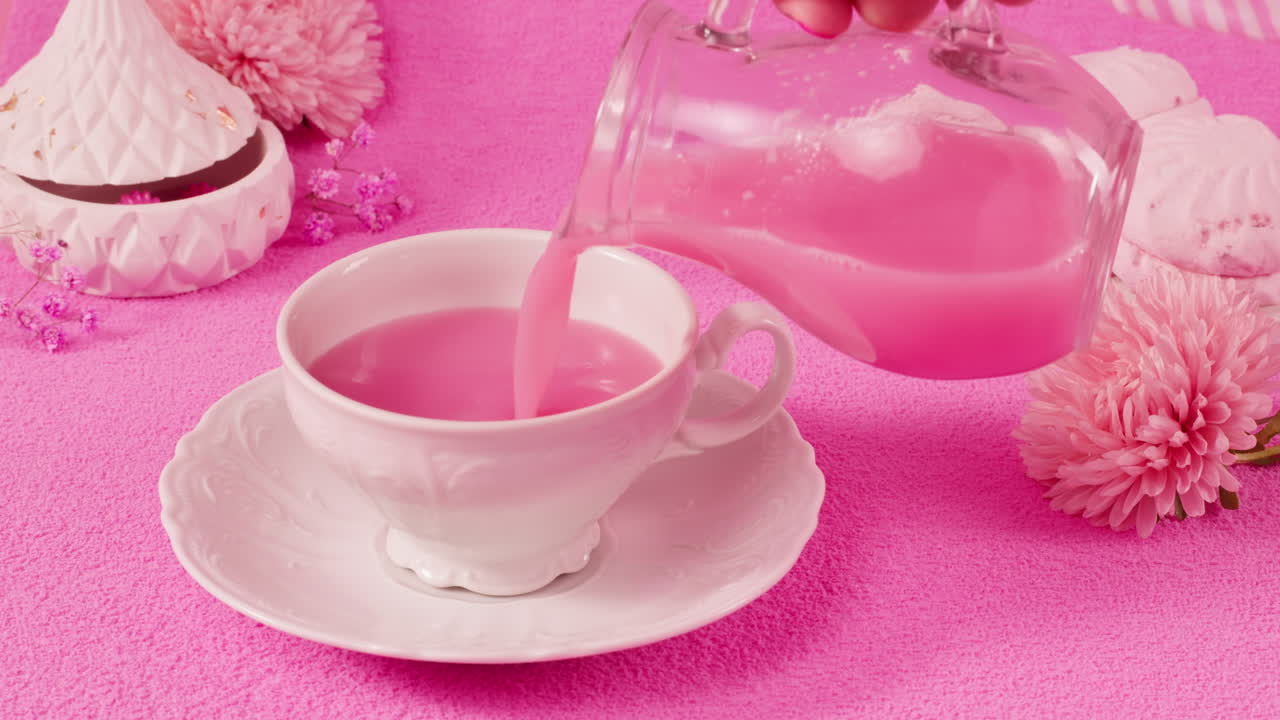 Pink Drink Being Poured into a Tea Cup
