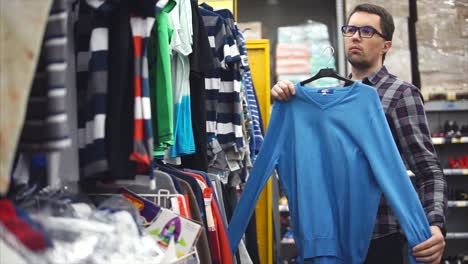 hombre comprando ropa en una tienda de ropa
