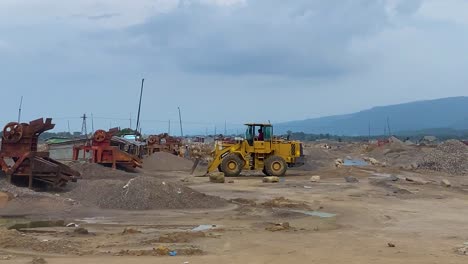 Driving-by-the-stone-crushing-site-in-Bholaganj,-Sylhet,-capturing-the-hustle-and-bustle-of-the-Asian-industry