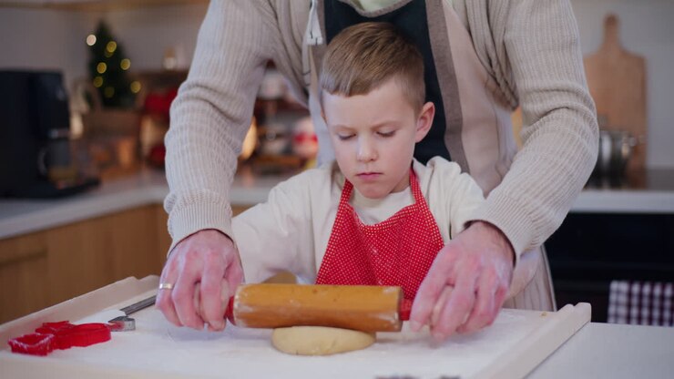 Dad Helps His Son Roll Out Dough In Kitchen