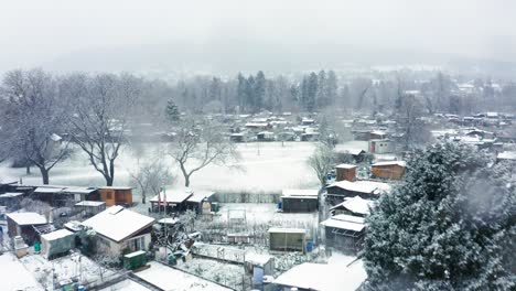 Vuelo-De-Avance-Rápido-En-Una-Ventisca-De-Nieve-Sobre-Jardines-De-Verano-Cubiertos-De-Nieve