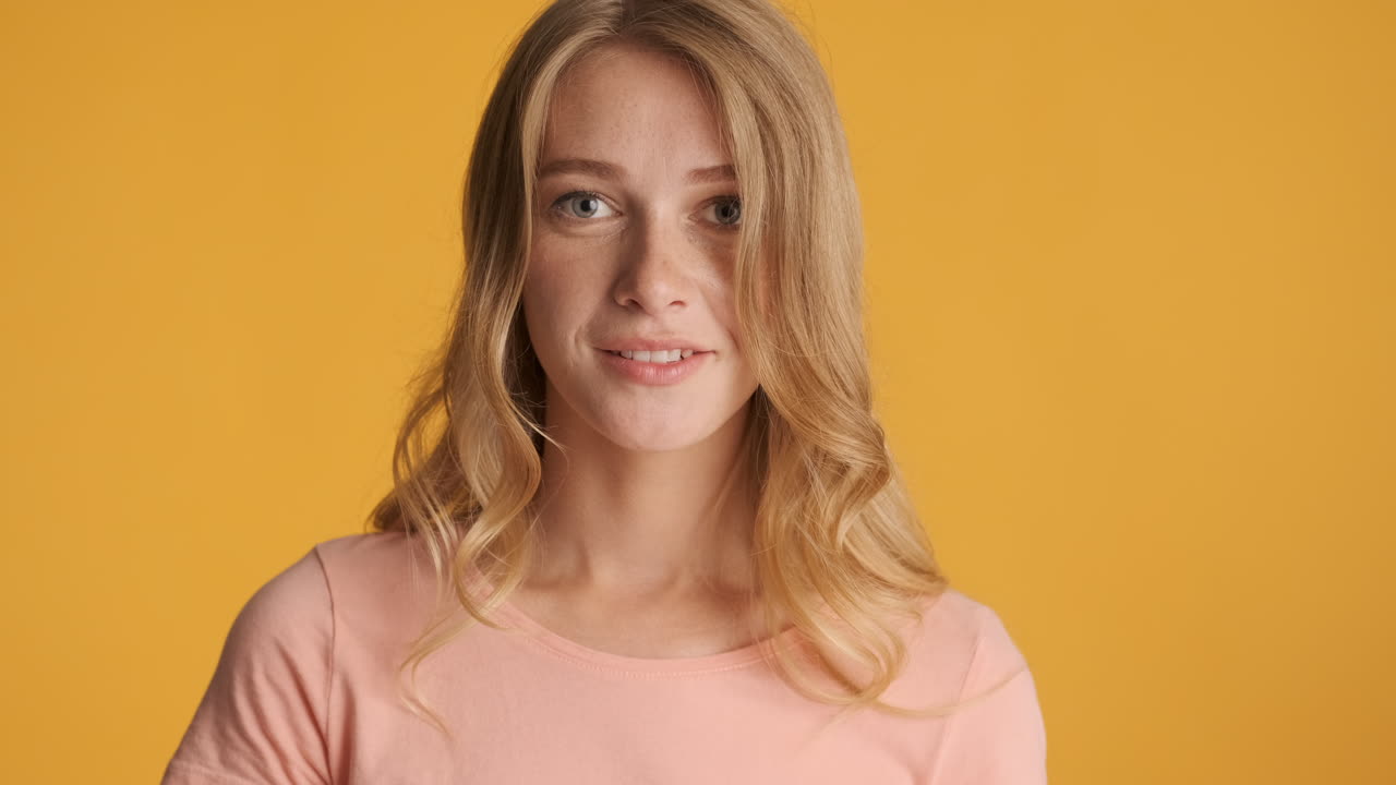 Caucasian woman calmly looking and smiling at camera.