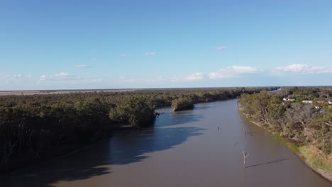 drone flying over a river in australia near a small country town