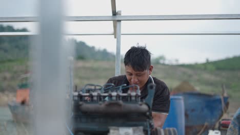 man repairing tractor engine