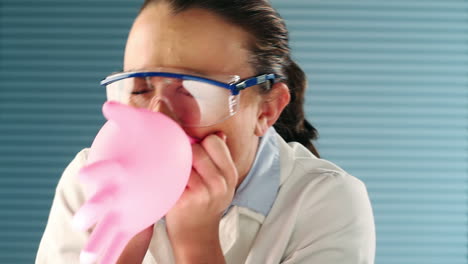 pretty medical student blowing balloon with glove